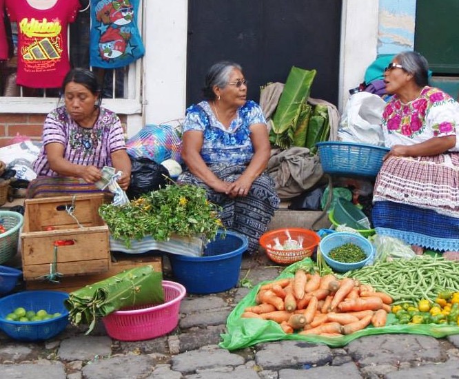 Ladies in traditional Mayan clothing selling fruit.